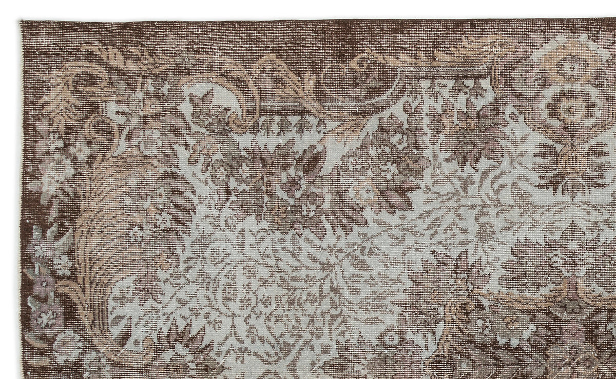 Dark brown and light blue vintage-style rug with a distressed floral medallion pattern.