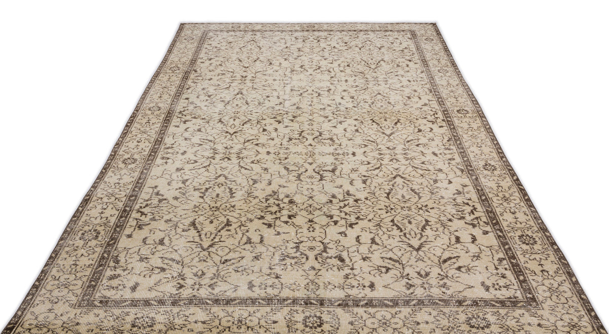 The Trabiane - Vintage Floral Rug (6'1 x 9'11) is a rectangular beige Anatolian vintage piece with intricate floral and vine motifs plus a decorative border, shown laid flat on a white background.
