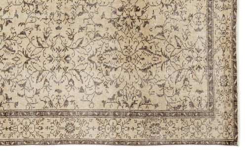 Load image 1 in gallery view. A close-up of the Trabiane - Vintage Floral Rug - 6'1 X 9'11 highlights intricate floral and geometric patterns in beige and brown, with symmetrical motifs, a decorative border, and a softly faded vintage look.