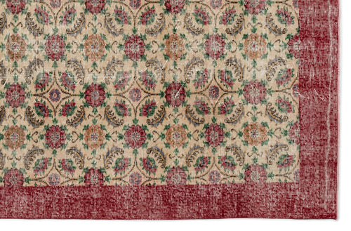 Load image 1 in gallery view. Beige rug with a repeating floral medallion pattern in red, green, and blue, featuring a wide distressed red border.