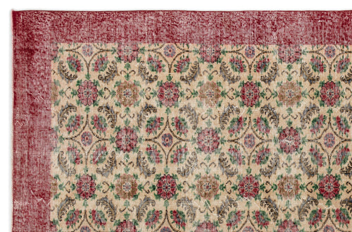 Load image 1 in gallery view. Beige rug with a distressed red border and a repeating floral medallion pattern in red, green, and brown.