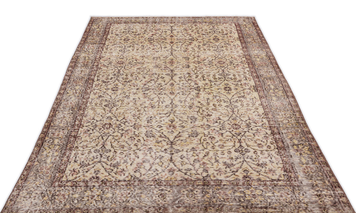 Beige and brown vintage-style rug with a distressed floral vine pattern and a wide decorative border.