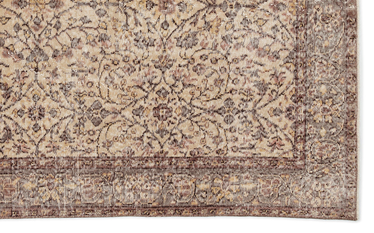 Beige and brown traditional rug with a distressed floral medallion pattern and a wide decorative border.