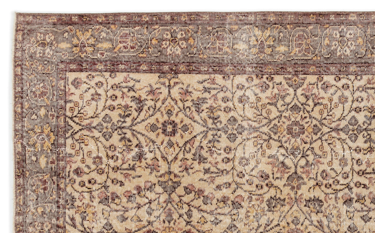 Beige and brown traditional rug with a distressed floral medallion pattern and a wide decorative border.