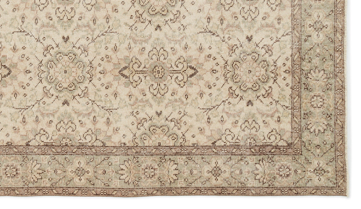 A close-up of the Glela - Vintage Floral Rug (5'0 X 8'11) in beige and light brown, showcasing floral and geometric patterns with a decorative border and vintage-inspired intricate details.