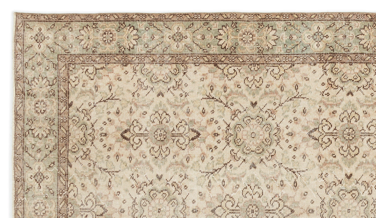 Detail of the Glela Vintage Floral Rug (5'0 X 8'11) with muted beige, brown, and green tones. The border showcases large floral motifs, while the inner area features a detailed repeating geometric and floral pattern.