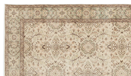 Load image 1 in gallery view. Detail of the Glela Vintage Floral Rug (5'0 X 8'11) with muted beige, brown, and green tones. The border showcases large floral motifs, while the inner area features a detailed repeating geometric and floral pattern.