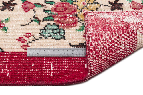 Load image 1 in gallery view. Cream rug with a floral pattern in red, yellow, and green, featuring a red border and a metal ruler for scale.