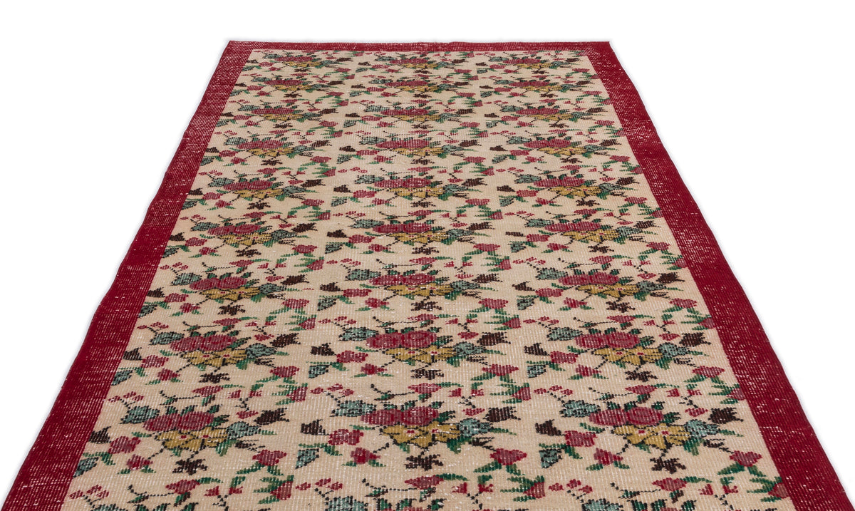 Beige runner rug with a red border and a repeating floral pattern in red, green, and yellow on a white background.