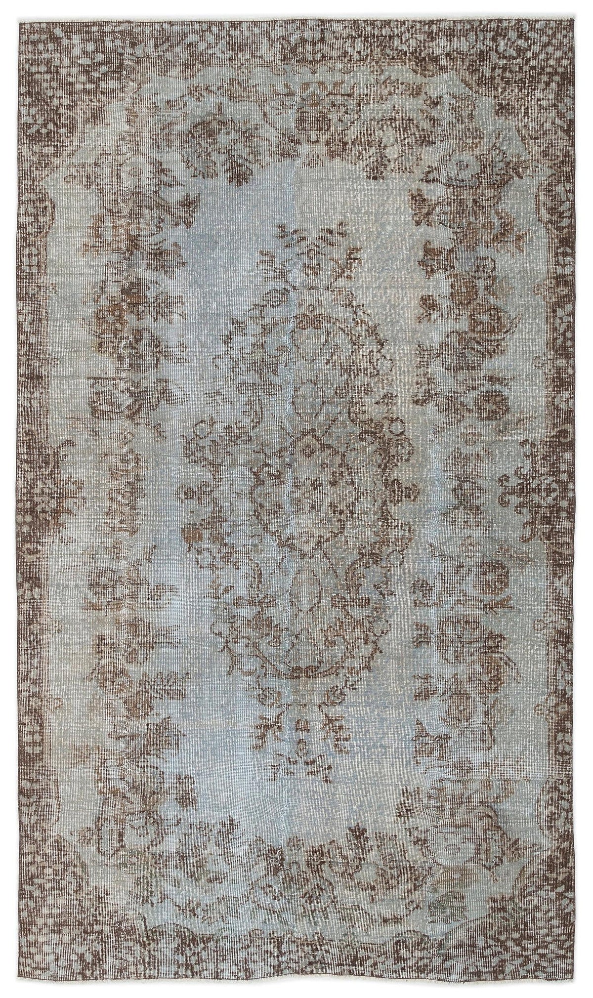 Light blue and brown distressed area rug with a central floral medallion and ornate border pattern.