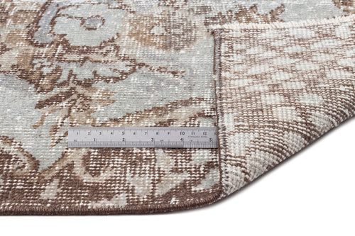 Load image 1 in gallery view. Distressed blue and brown floral medallion rug with a folded corner revealing the woven backing and a metal ruler.