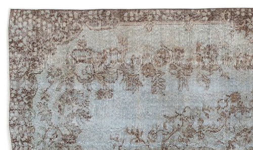 Load image 1 in gallery view. Brown and light blue distressed rug with a faded floral medallion pattern.