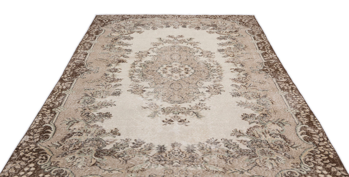 Beige and brown distressed traditional rug with a central floral medallion and ornate border on a white background.