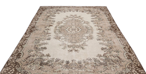 Load image 1 in gallery view. Beige and brown distressed traditional rug with a central floral medallion and ornate border on a white background.