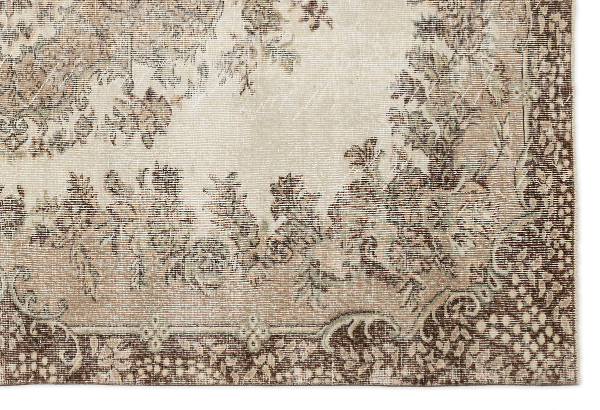 Beige and brown vintage-style rug with a distressed floral medallion pattern and a detailed border.