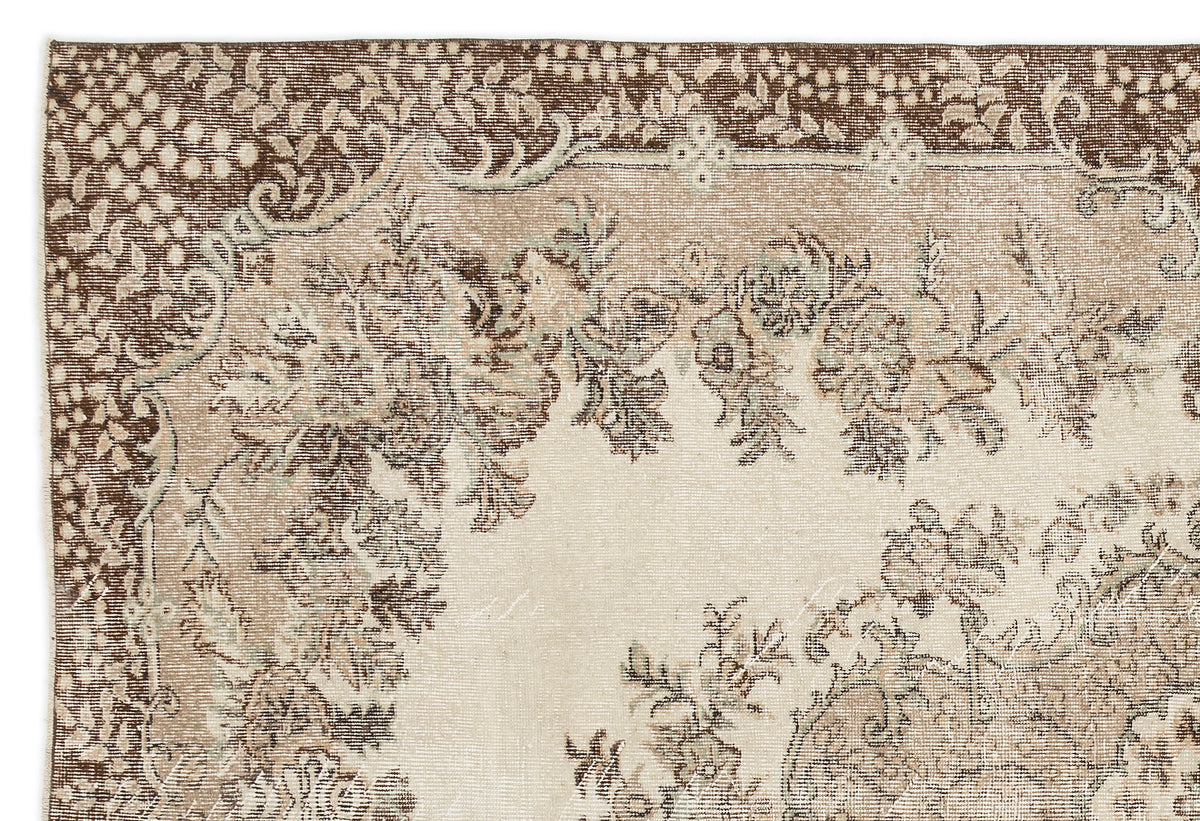 Beige and brown vintage-style rug with a distressed floral medallion pattern and ornate border.