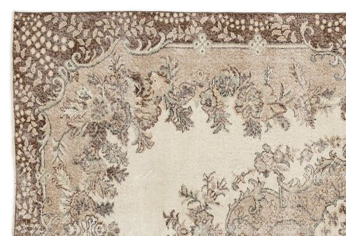 Load image 1 in gallery view. Beige and brown vintage-style rug with a distressed floral medallion pattern and ornate border.