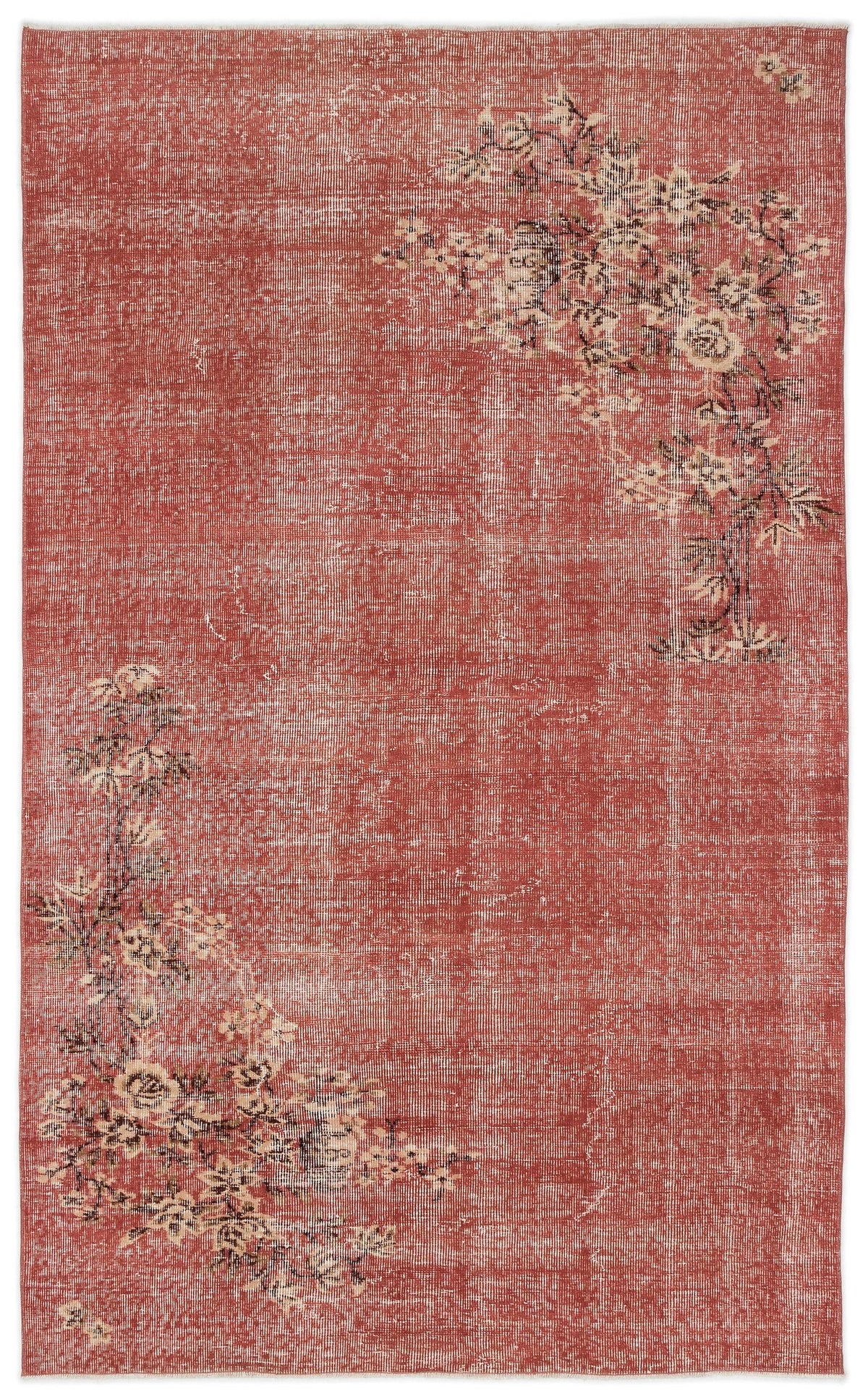 Distressed terracotta rug with cream and black floral branch motifs in opposite corners.
