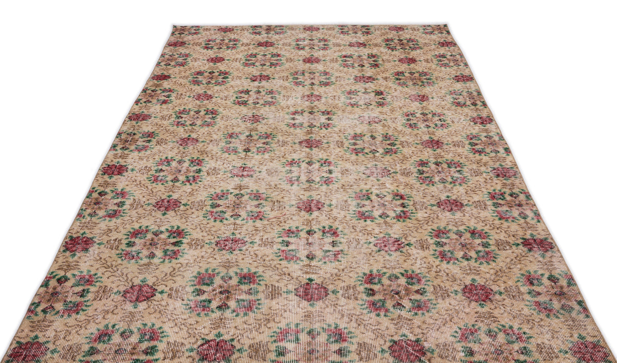 Beige vintage-style rug with a repeating floral medallion pattern in muted red and green on a white background.