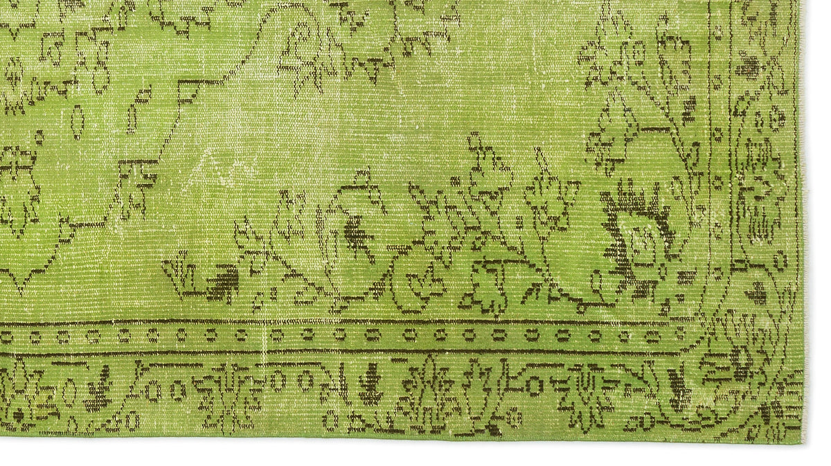 Lime green rug with a distressed dark brown floral and geometric border pattern on a white background.