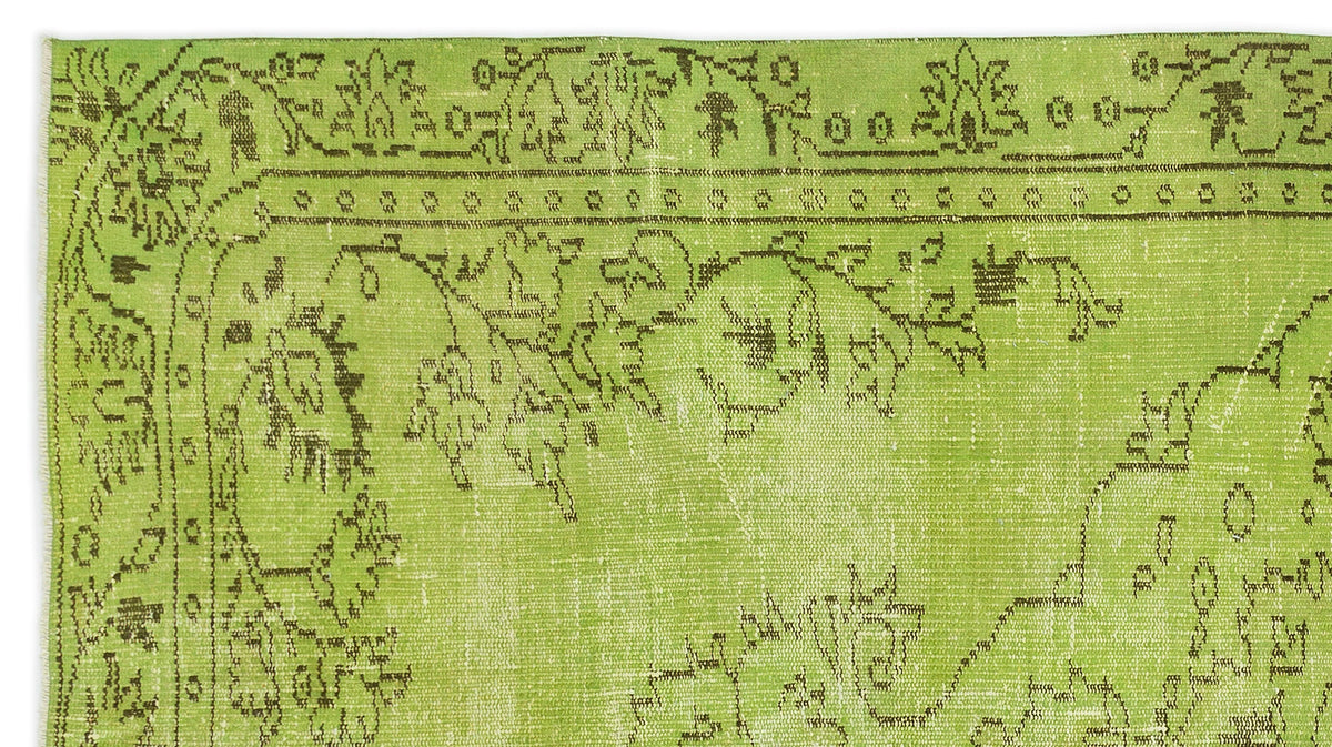 Bright lime green rug with a distressed dark brown floral medallion pattern and decorative border.