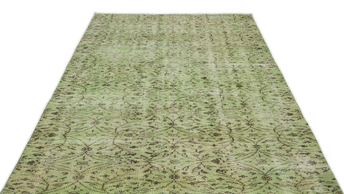 Sage green distressed rug with a dark brown repeating floral medallion pattern on a white background.