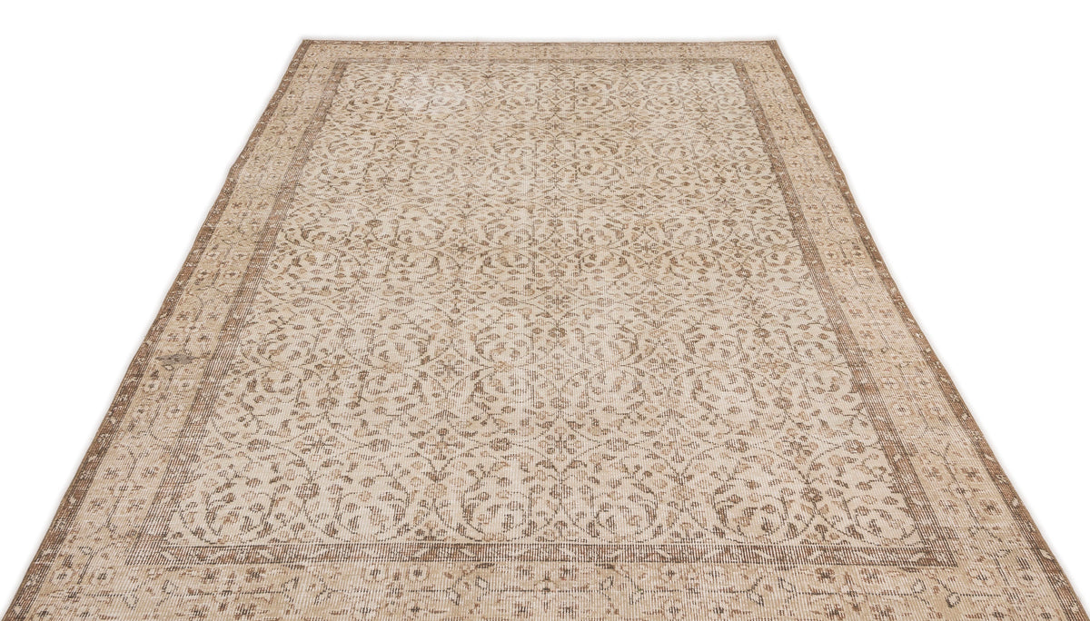 The Pavia - Vintage Floral Rug (5'7 x 9'5) is a beige and light brown Anatolian hand-woven piece with detailed floral and vine motifs and a decorative border, shown on a white background.