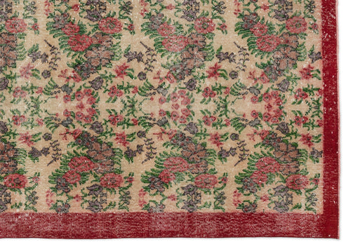 Load image 1 in gallery view. Beige rug with a distressed floral pattern in red, green, and dark purple, featuring a solid red border.