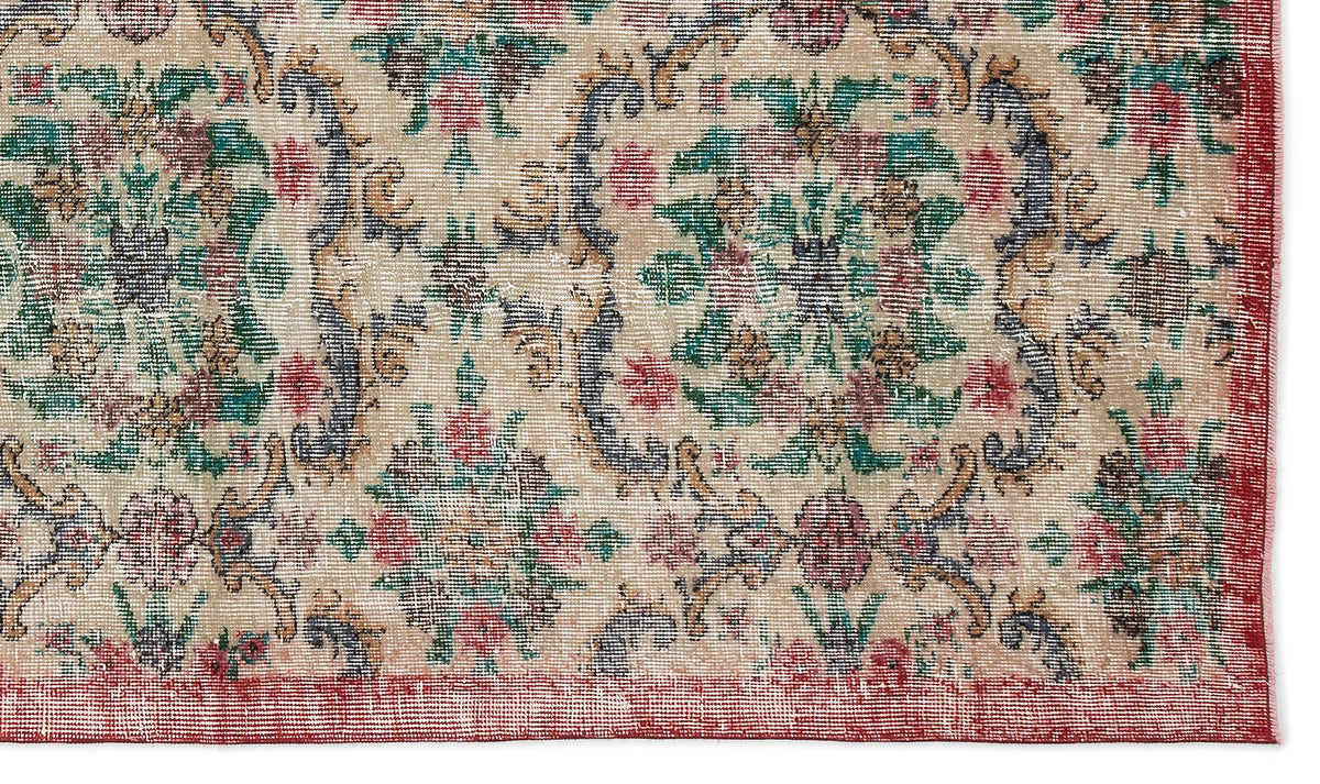 Beige traditional rug with a distressed floral medallion pattern in red, green, and blue, featuring a red border.