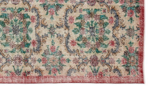 Load image 1 in gallery view. Beige traditional rug with a distressed floral medallion pattern in red, green, and blue, featuring a red border.