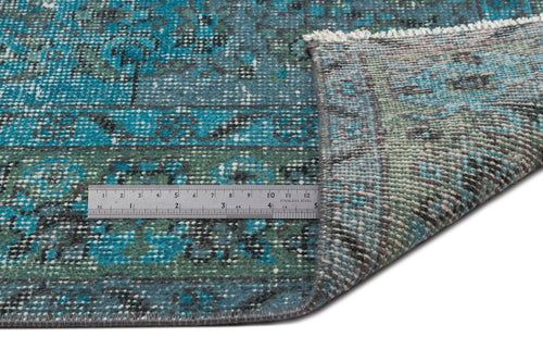 Load image 1 in gallery view. Teal and black distressed traditional rug with a folded corner and a metal ruler for scale on a white background.