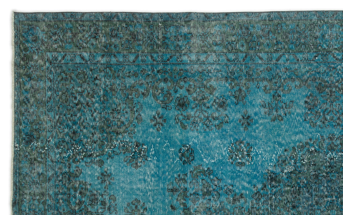 Teal and dark grey distressed rug with a traditional floral medallion pattern and a bordered edge.
