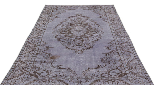 Load image 1 in gallery view. Lavender and brown distressed vintage-style rug with a central floral medallion and ornate border.