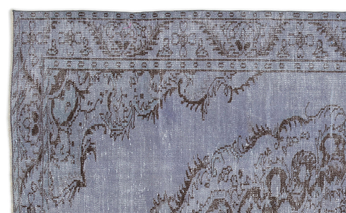 Periwinkle and dark brown distressed rug with a traditional ornate floral border and central medallion pattern.