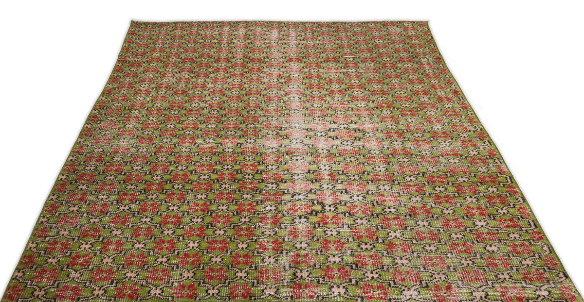 Green, red, and black geometric patterned rug with a distressed, faded center stripe on a white background.