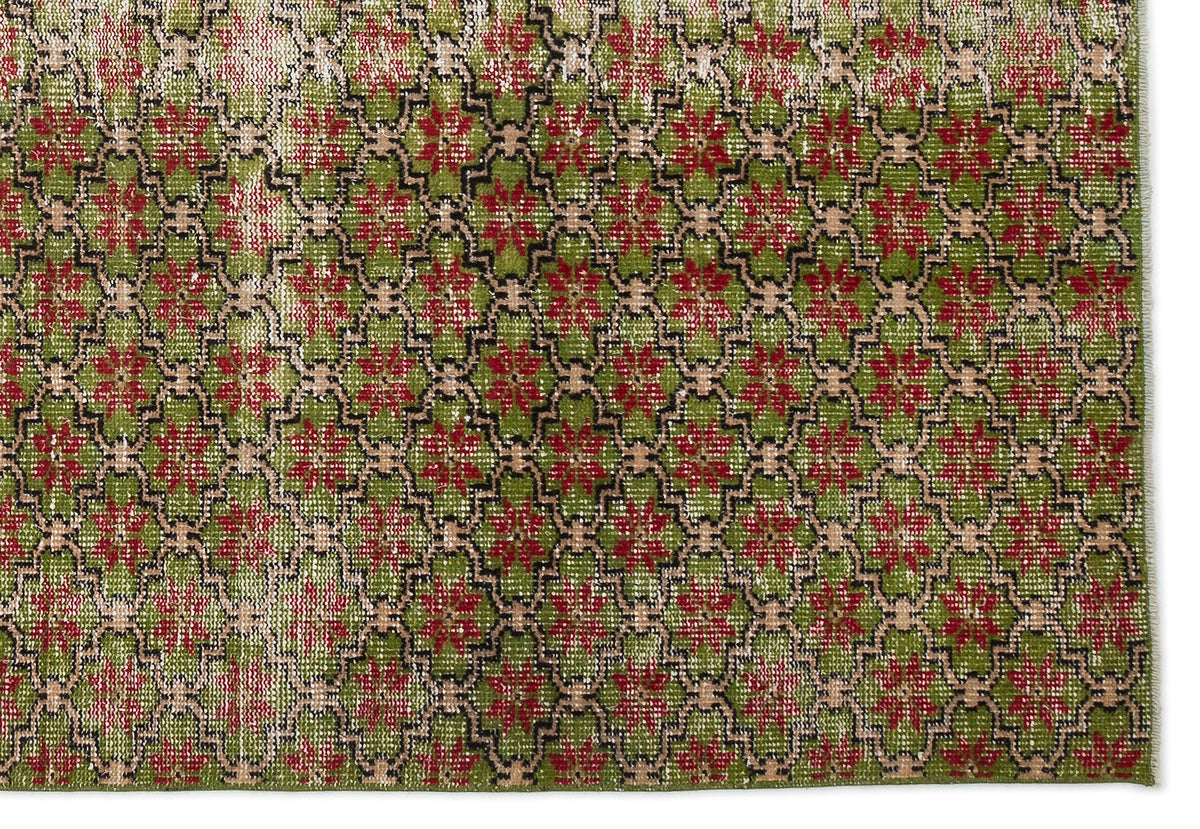Distressed green and red rug with a repeating geometric lattice pattern and beige accents.