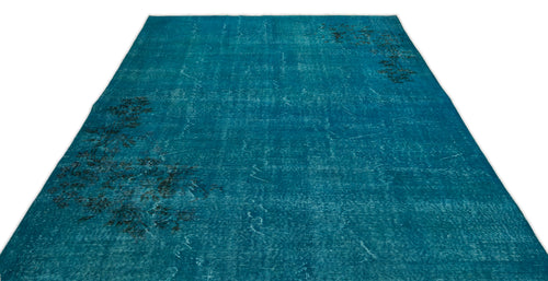 Load image 1 in gallery view. Teal distressed area rug with a faded, dark floral pattern on a white background.