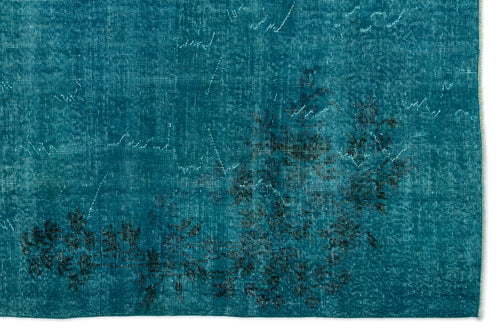 Load image 1 in gallery view. Teal distressed rug with a faded black floral motif and visible woven texture.