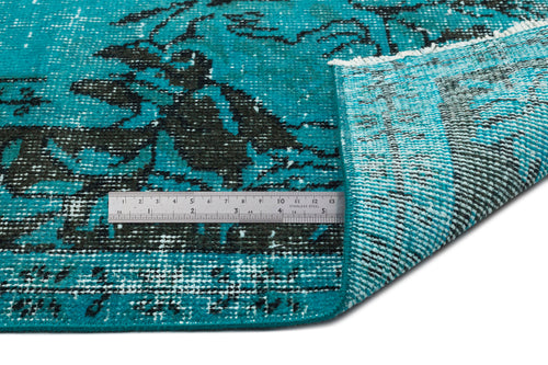 Load image 1 in gallery view. Teal and black distressed floral pattern rug with a folded corner and a metal ruler for scale.