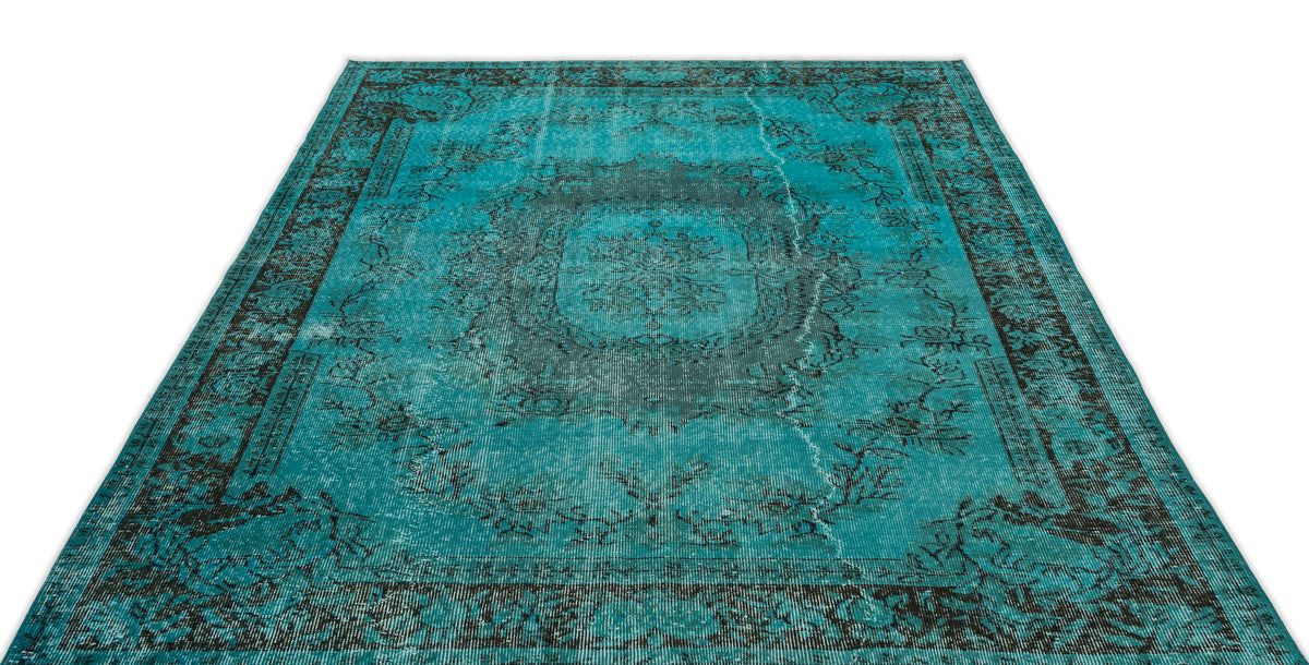 Distressed turquoise and black area rug with a traditional central medallion and ornate border pattern.
