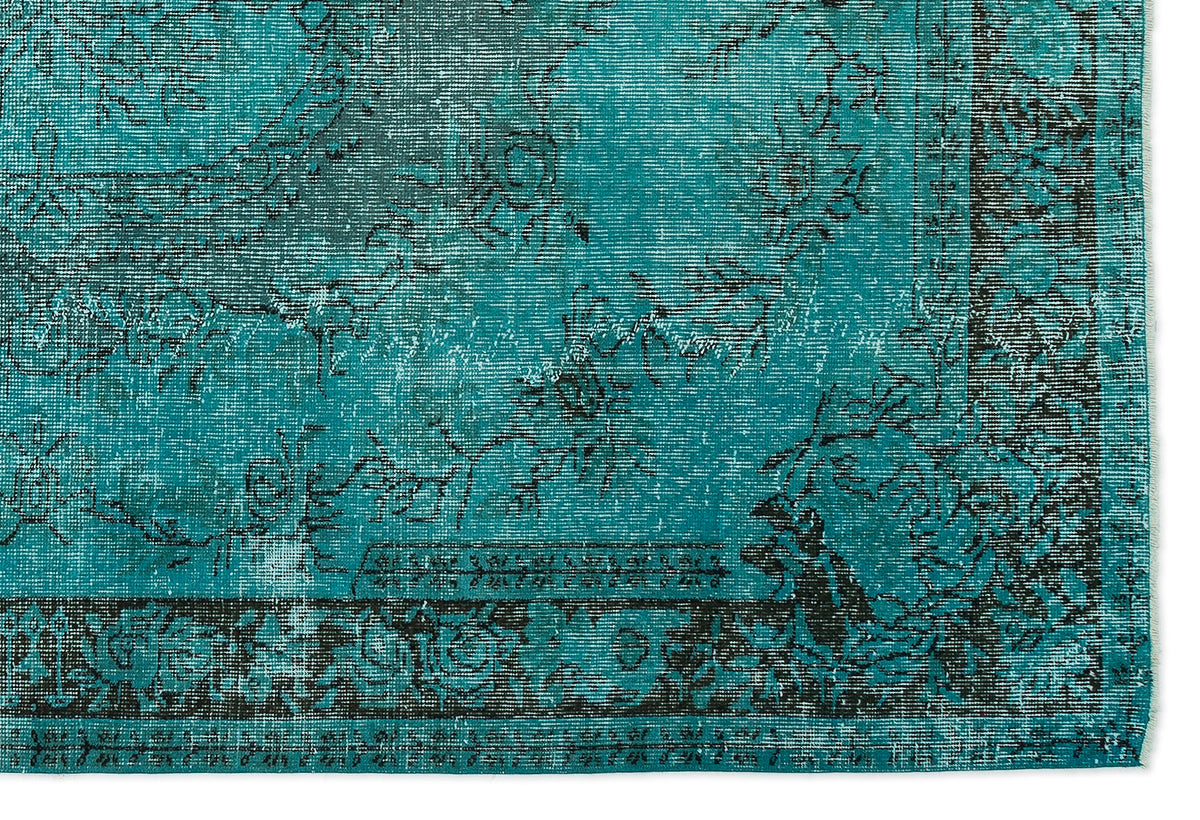 Teal and black rug with a distressed traditional floral medallion pattern and a decorative border.