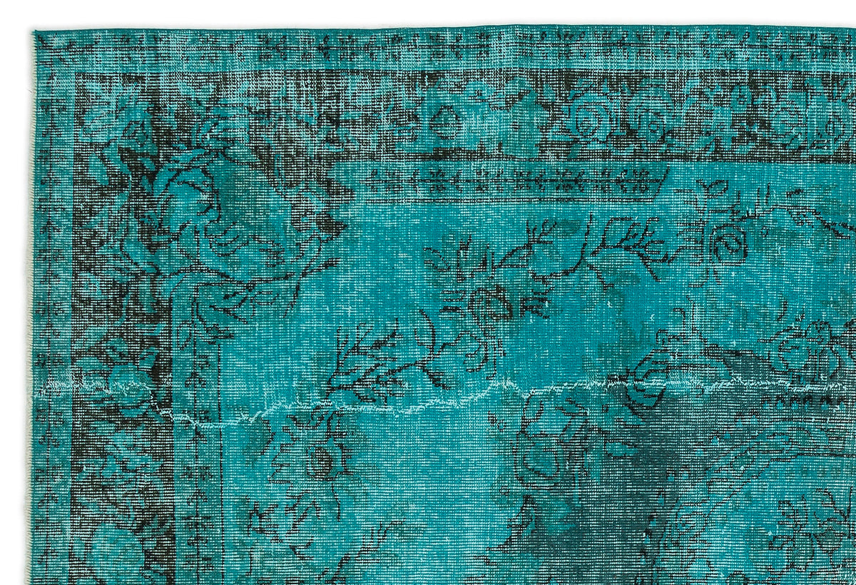 Teal and black distressed rug with a traditional floral medallion pattern and a decorative border.