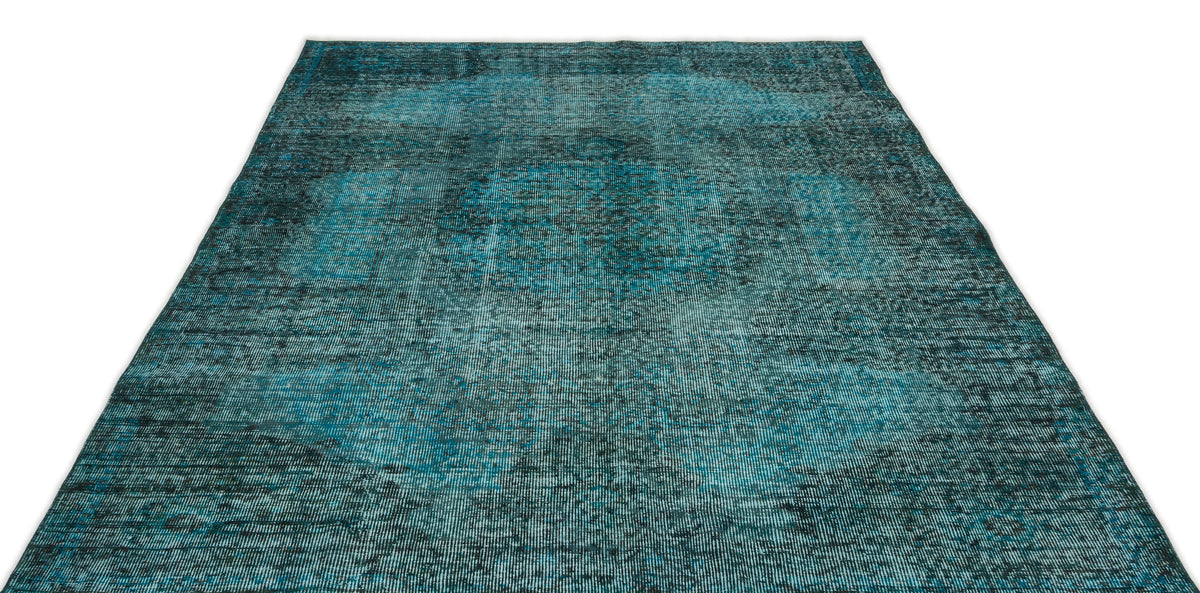 Teal and black distressed vintage-style rug with a faded central medallion pattern on a white background.