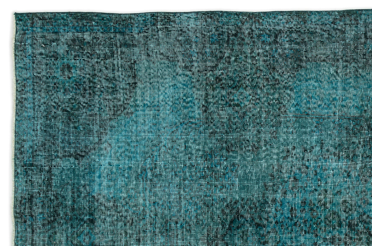 Teal and black distressed vintage-style rug with a faded, worn-in texture.