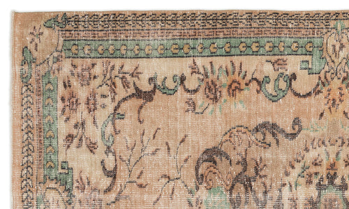 Load image 1 in gallery view. Tan vintage-style rug with a distressed floral medallion pattern, green border accents, and dark brown geometric detailing.
