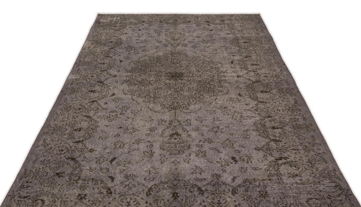 Charcoal grey distressed rug with a traditional central medallion and ornate floral motifs on a white background.