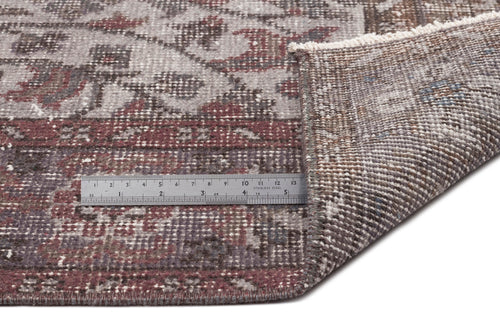 Load image 1 in gallery view. Distressed grey and burgundy floral medallion rug with a folded corner and a metal ruler for scale.