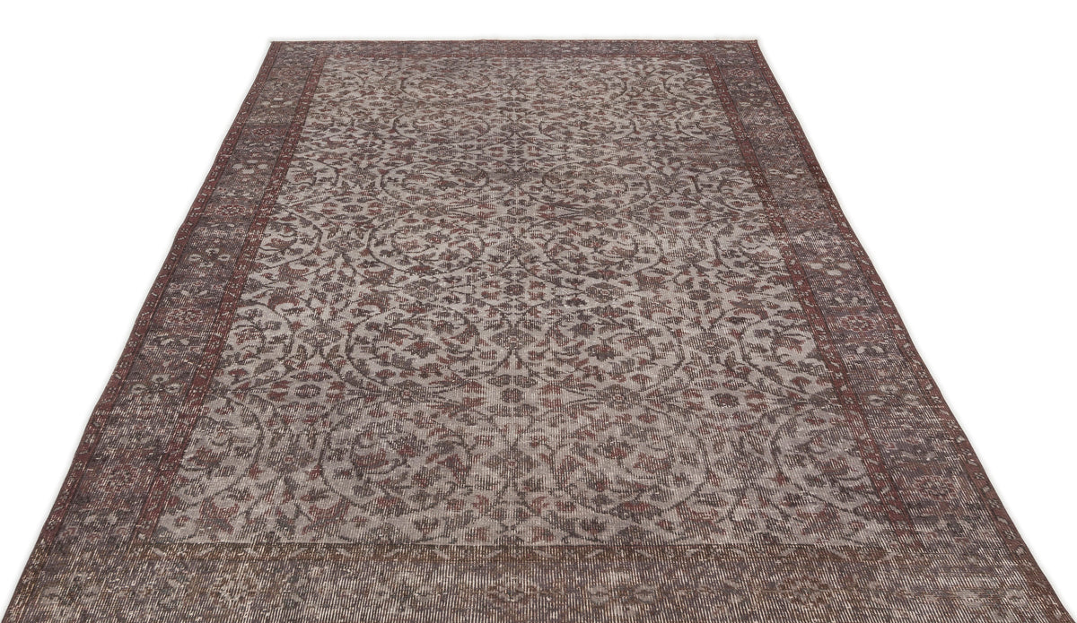 Distressed brown and grey traditional rug with an intricate floral medallion pattern and a wide decorative border.