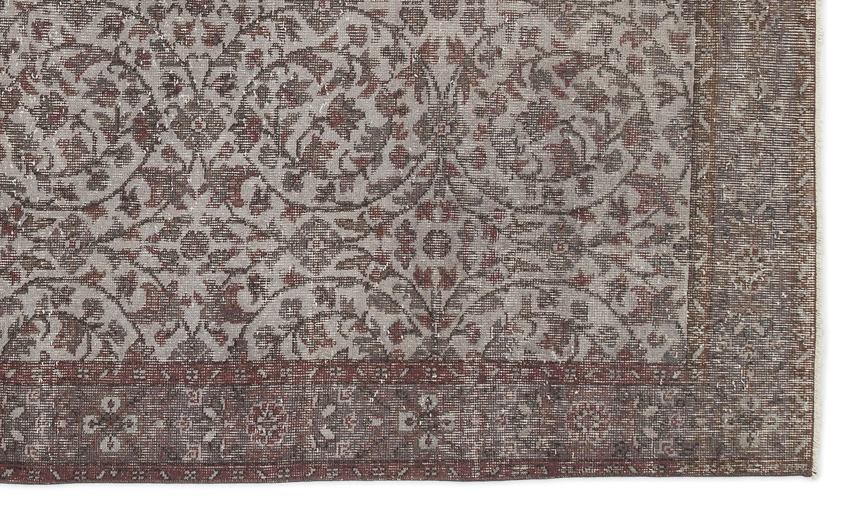 Distressed grey and rust-red rug with a traditional floral medallion pattern and a wide, ornate border.