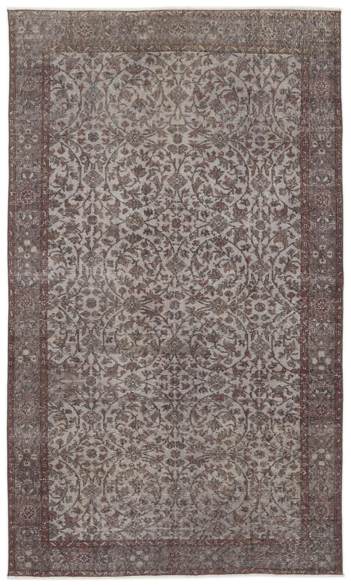 Brown and grey distressed rug with a traditional floral medallion pattern and a wide decorative border.